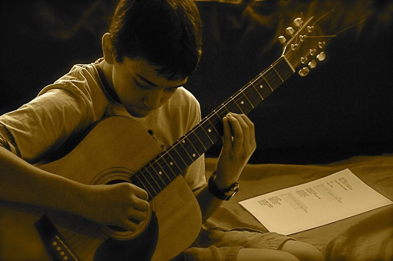 Beginner practising chords on an acoustic guitar